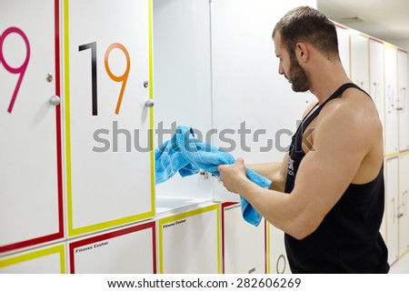 fitness adult man in locker room of gym facility. Modern fitness studio.