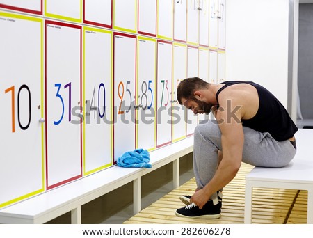 fitness adult man in locker room of gym facility. Modern fitness studio.