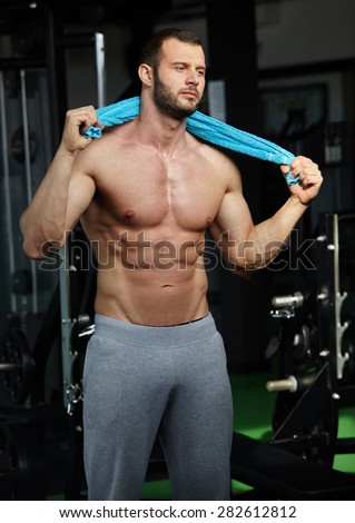 Strong Athletic Man Fitness Model Torso showing six pack abs in modern gym