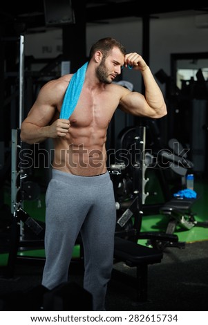 Strong Athletic Man Fitness Model Torso showing six pack abs in modern gym