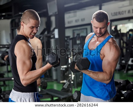 personal trainer helping man to fill the membership form of health club