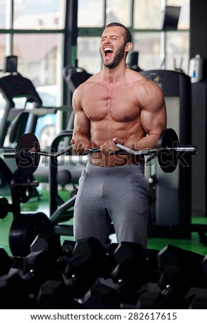 Adult man with weight training equipment on sport modern gym
