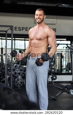 Adult man with weight training equipment on sport modern gym