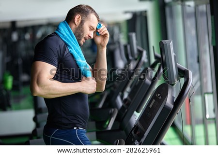 Man running in a modern  gym on a treadmill concept for exercising, fitness and healthy lifestyle