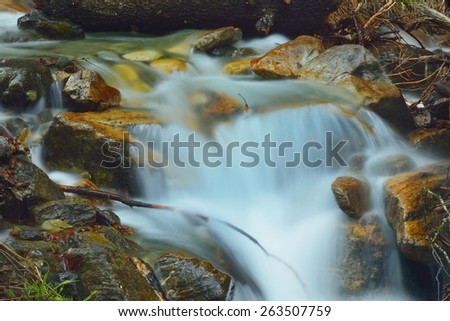 This is light river in Caucasus mountains in spring