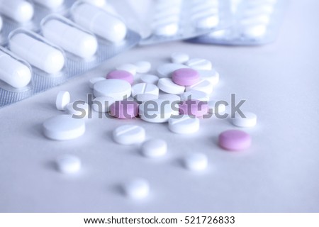 Pharmacy theme, medicine tablets and capsules on a light background.