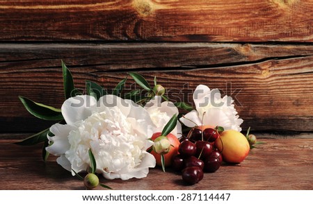 Peony, cherry and peach. Still life with fresh berries and flowers.