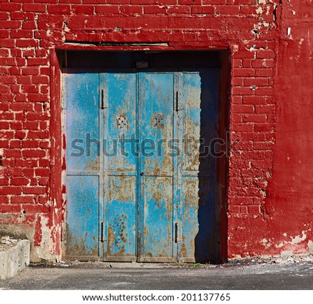 blue garage door in red purpure brick wall