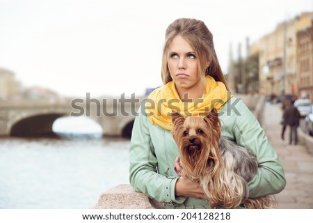 sad girl with little dog on the bank of the river after conflict with her friend. toned instagram.