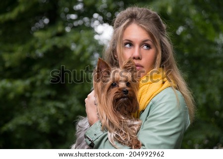 sad frightened blonde young woman with dog in the park