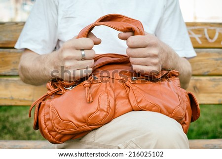 man hands grip the woman bag