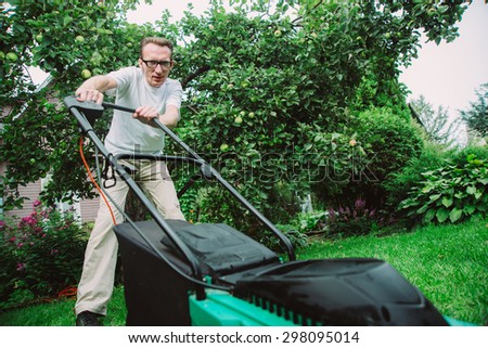 man with lawn mower on his backyard