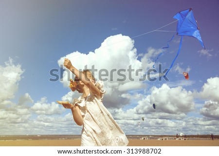Girl 6-7 years old launch the kite at the seashore, running and laughing.