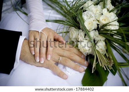 close up of the hands of bride and groom and wedding bouquet