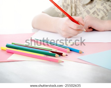 boy draws pencils sitting for a table