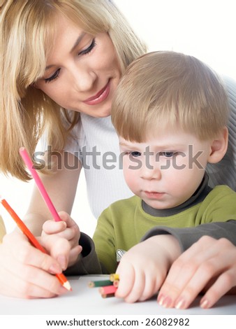 The little boy draws pencils with mum