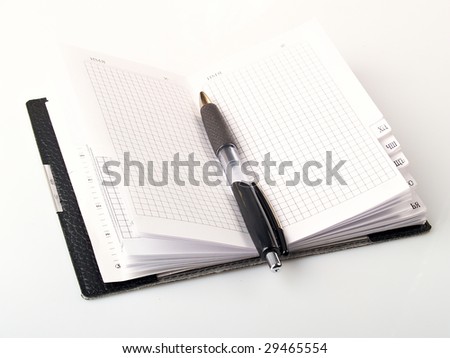 Pen on notebook, isolated on white background.