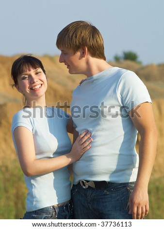 Young guy and the girl cost at top of a hill