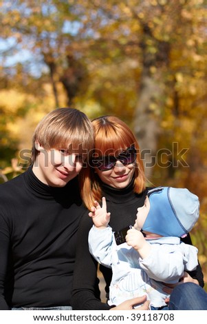 Happy family on walk in park in the autumn