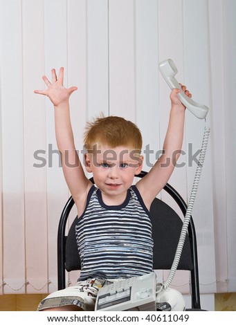 The little boy sits with a telephone tube in hands