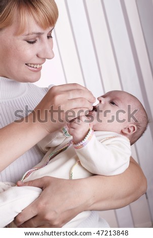 Young happy mother hugging baby on the white background