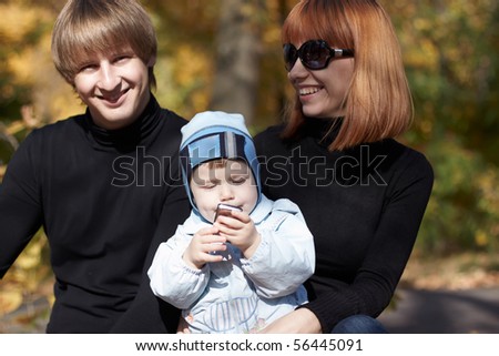 Happy family on walk in park in the autumn