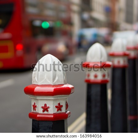 Colorful steel fence in city of London over blurred red London bus.