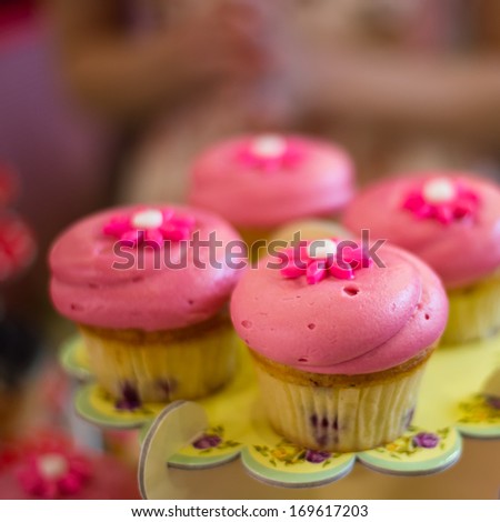 Cakes with rose macaroons on colorful stand in the market bakery.