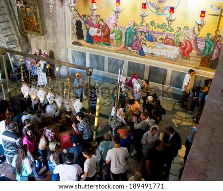 JERUSALEM, ISRAEL - APRIL 21, 2014 : Pilgrims round  Stone of Agony at the enter to Holy Sepulche  Church in Jerusalem during  Easter Sunday on April 21, 2014. This place is known as Golgotha Altar.