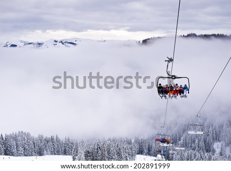 ELLMAU, AUSTRIA - JANUARY 27, 2014 : Unidentified skiers on ski lift chair in foggy day at Ellmau, Austria on January 27, 2014.  Ellmau is very popular ski resort in Tirol  Austria.