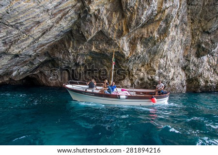 CAPRI, ITALY - MAY 08, 2015 : Unidentified tourists at the boat over rocks of isle of Capri, Italy.