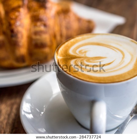 Cap of cappuccino and croissant  for breakfast.