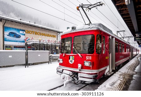 KLISTERS, SWITZERLAND - JANUARY 17, 2015 : Red train at Klosters train station during snow fall in Klosters, Switzerland.
