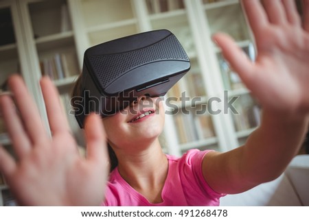 Girl looking through virtual reality headset in living room at home