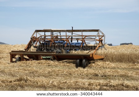 SWARTLAND REGION SOUTH AFRICA - OCTOBER 2015 - Harvesting wheat using a tractor and a row crop cutter in the Swartland region of South Africa