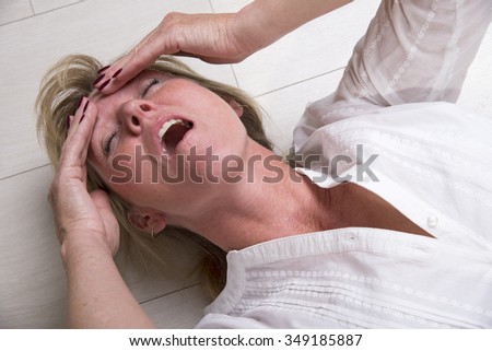 Woman laying on the floor with mouth open