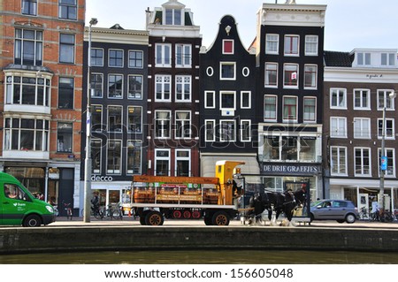 AMSTERDAM, NETHERLANDS - MARCH 27: Typical black houses on the street by the river on March 27, 2012. Amsterdam is the capital and most populous city of the Netherlands.