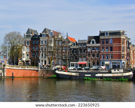 AMSTERDAM, NETHERLANDS - MARCH 27: Houses on the street by the river in Amsterdam on March 27, 2012. Amsterdam is the capital and most populous city of the Netherlands.