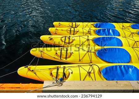 Yellow canoes, kayaks , 5 pieces, are on the water, attached to the shore, shrouded , tied a rope to the castle , around the water shines