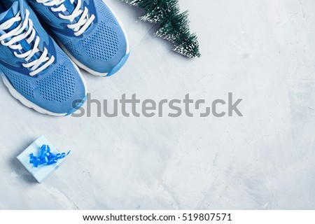 Christmas sport flat lay composition with shoes, christmas tree and blue gift box on gray \
concrete background. Concept CÂ�hristmas special for healthy lifestyle and sport.