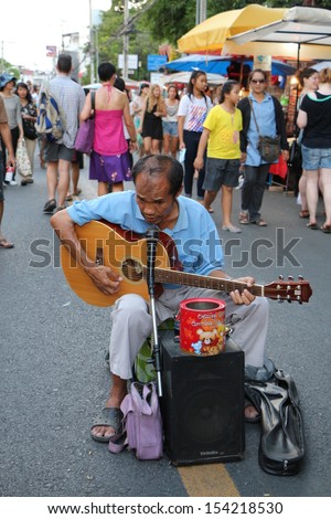 CHIANGMAI, THAILAND - JULY 27 :Unidentified street musician plays guitar at walking street market in Chiangmai,Thailand on 27 July 2013