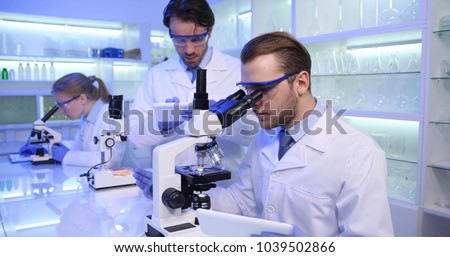 Researchers Team Testing Microscopic Sample on Microscope Laboratory, Future Science Research Project Activity