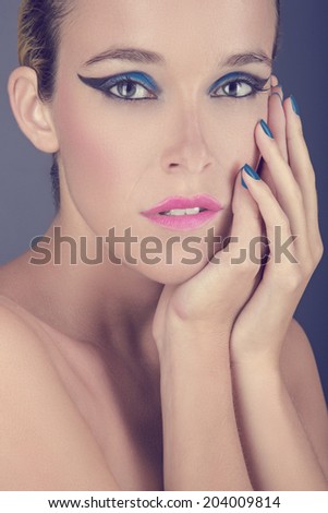 Beauty portrait of young woman against blue background