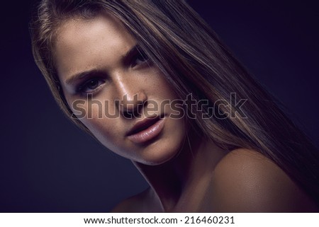 Beauty portrait of young sexy woman against dark blue background