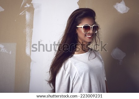 Fashion portrait of young smiling sexy woman against grunge background