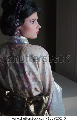 Traditional Japanese geisha woman with extreme makeup and traditional clothing