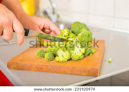 Cutting off  broccoli on the wooden board washed cutted and ready for cooking