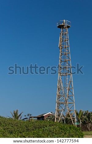 Rotating lighthouse beacon on an aluminium lattice tower, fitted with a triangular daymark.