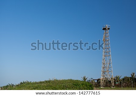 Rotating lighthouse beacon on an aluminium lattice tower, fitted with a triangular daymark.
