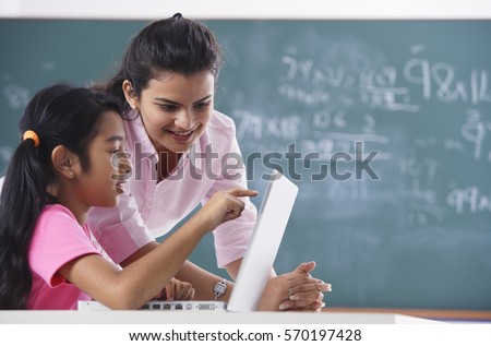 teacher and student at laptop, girl pointing at screen